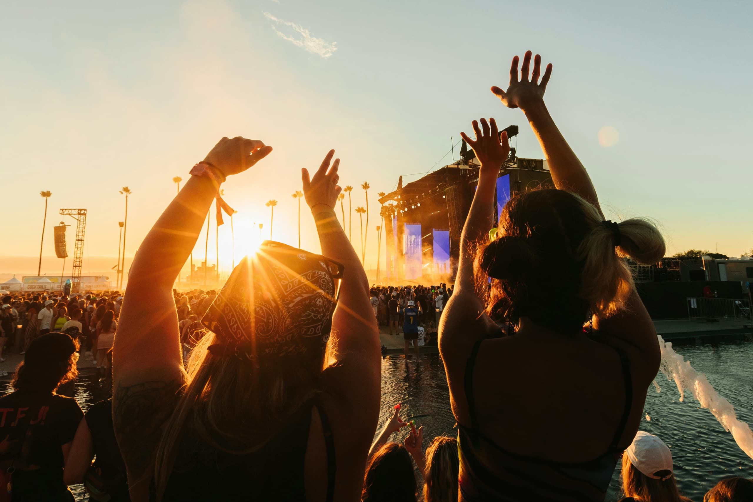 Crowd with hands raised at a Flipside event during golden hour
