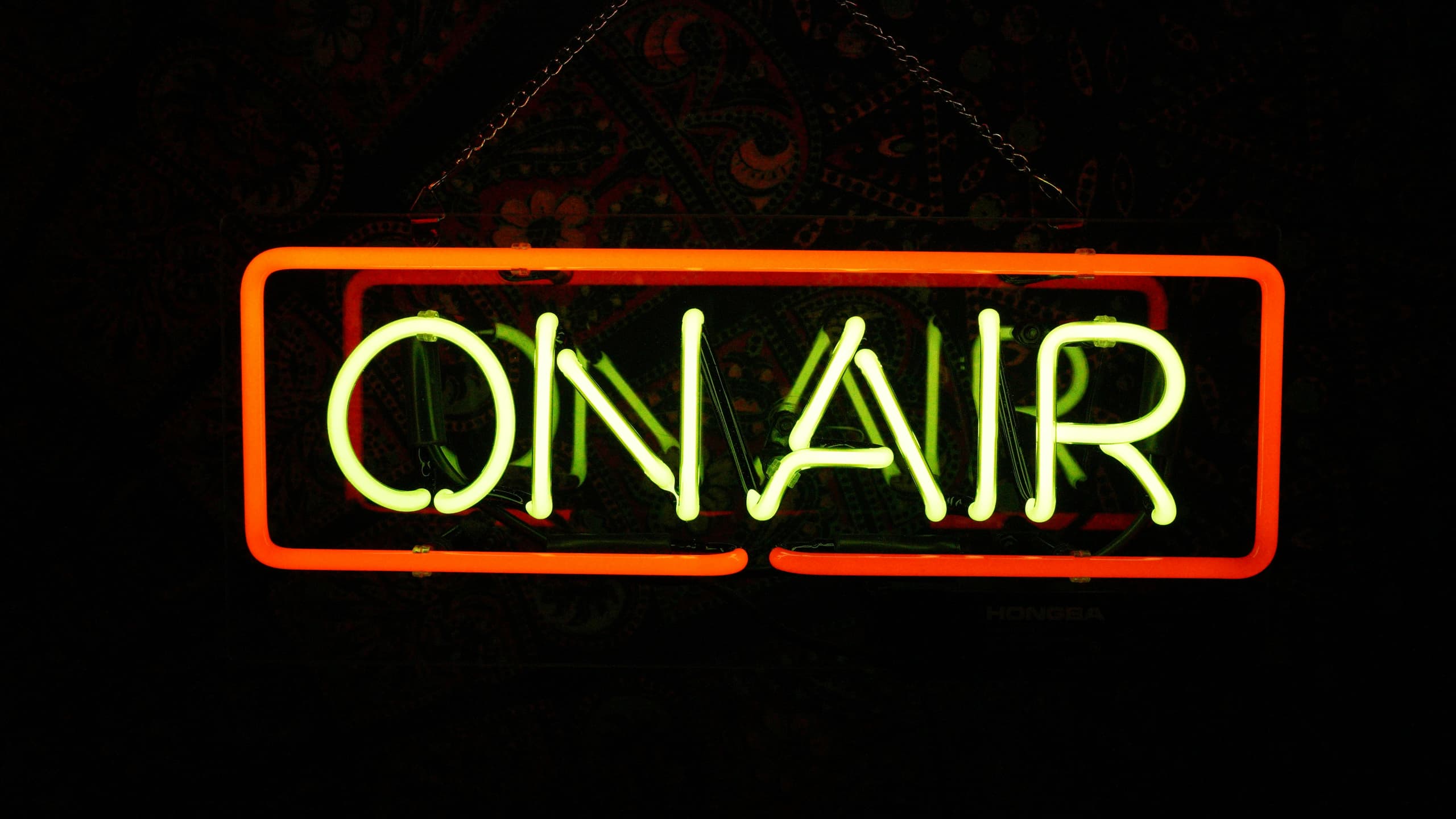 A glowing red and green neon 'On Air' sign